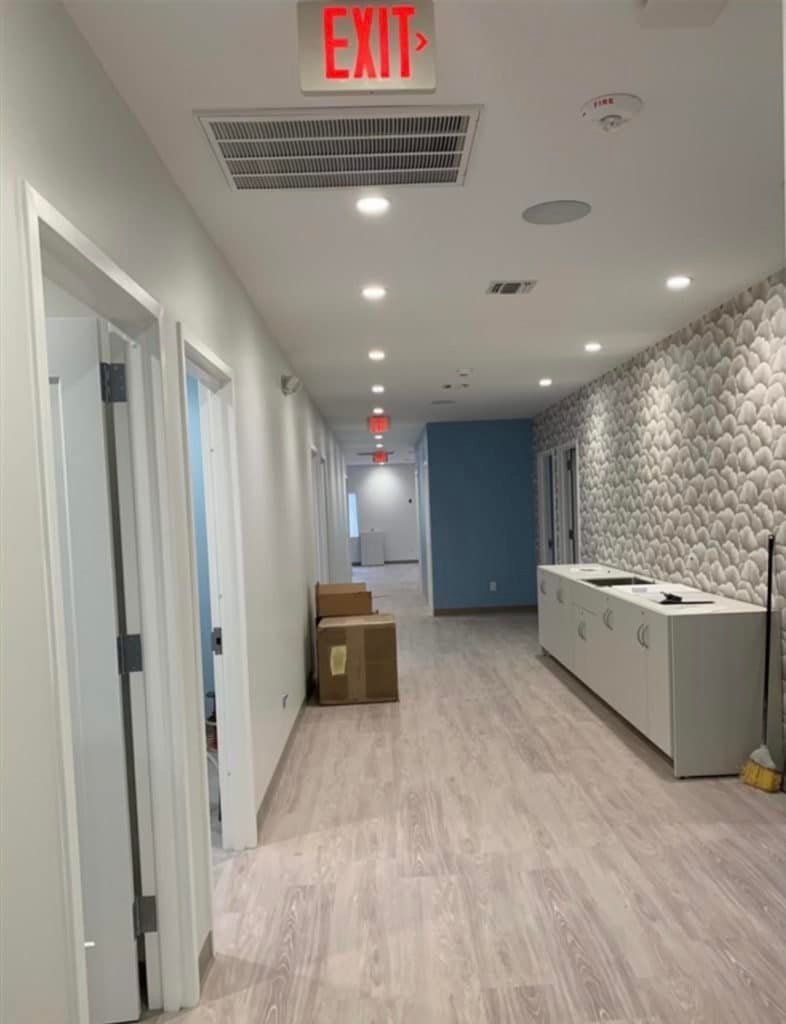 Commercial corridor fit-out with new plank flooring, recessed lighting and exit signage by T and J All In Remodeling in Waukesha County, Wisconsin