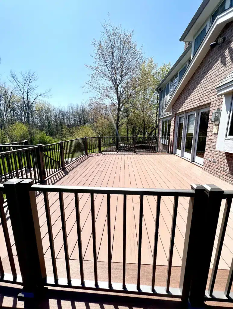 Wisconsin composite deck with cable railing and frost-depth footings on a Waukesha County home