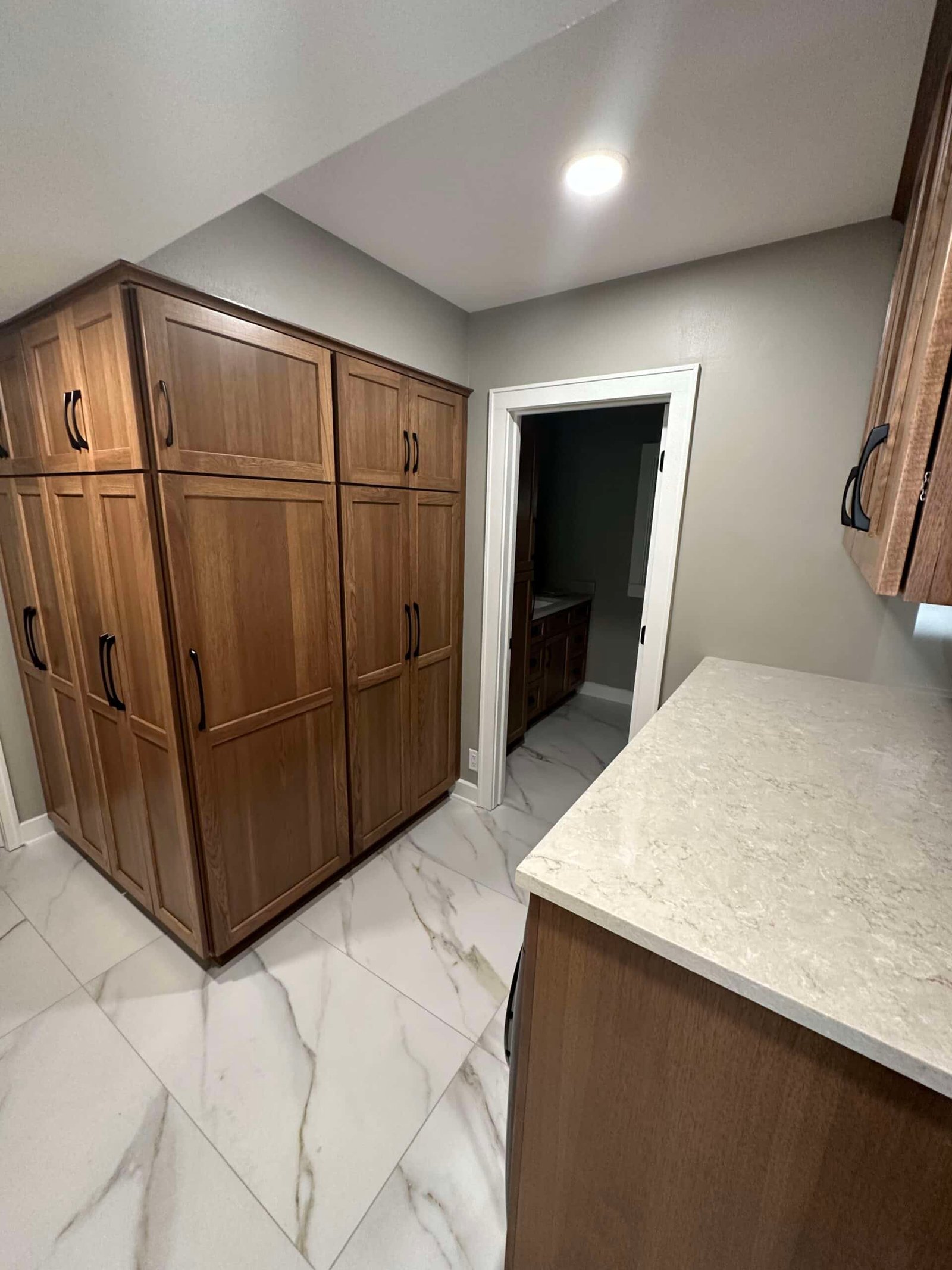 Custom walnut cabinetry and quartz countertop in a remodeled home by T&J All In Remodeling in Menomonee Falls, Wisconsin