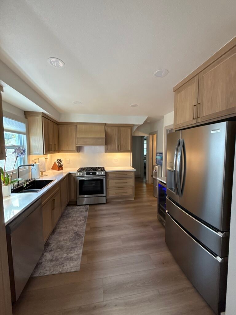 Remodeled kitchen with warm wood cabinets, under-cabinet lighting and a stainless gas range