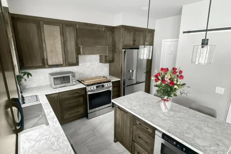 Grey stained kitchen with island seating and a glass pendant, a completed T And J kitchen remodel in Southeastern Wisconsin